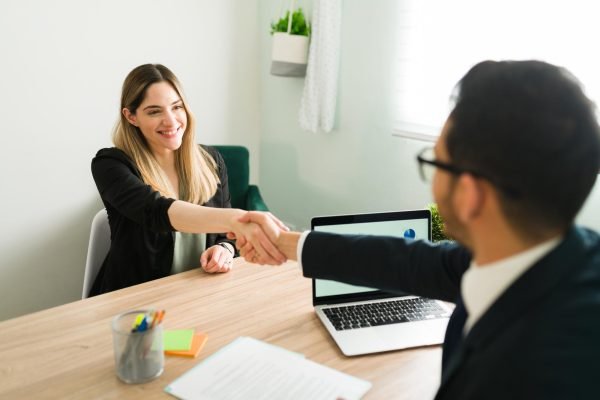 happy-caucasian-woman-shaking-hands-with-latin-man-during-business-meeting-with-lawyer-manager-hiring-beautiful-professional-woman-new-job