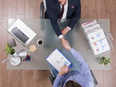 top-view-businessmen-shaking-hands-during-business-negotiation-startup-office